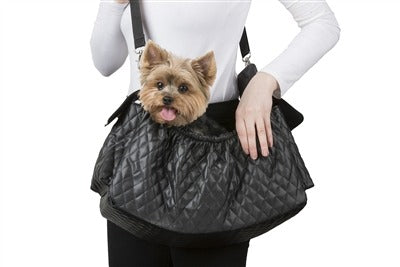 Black quilted sling dog carrier bag holding a small dog, with adjustable shoulder straps
