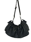 Black quilted sling dog carrier bag with shiny patent trim and adjustable shoulder straps